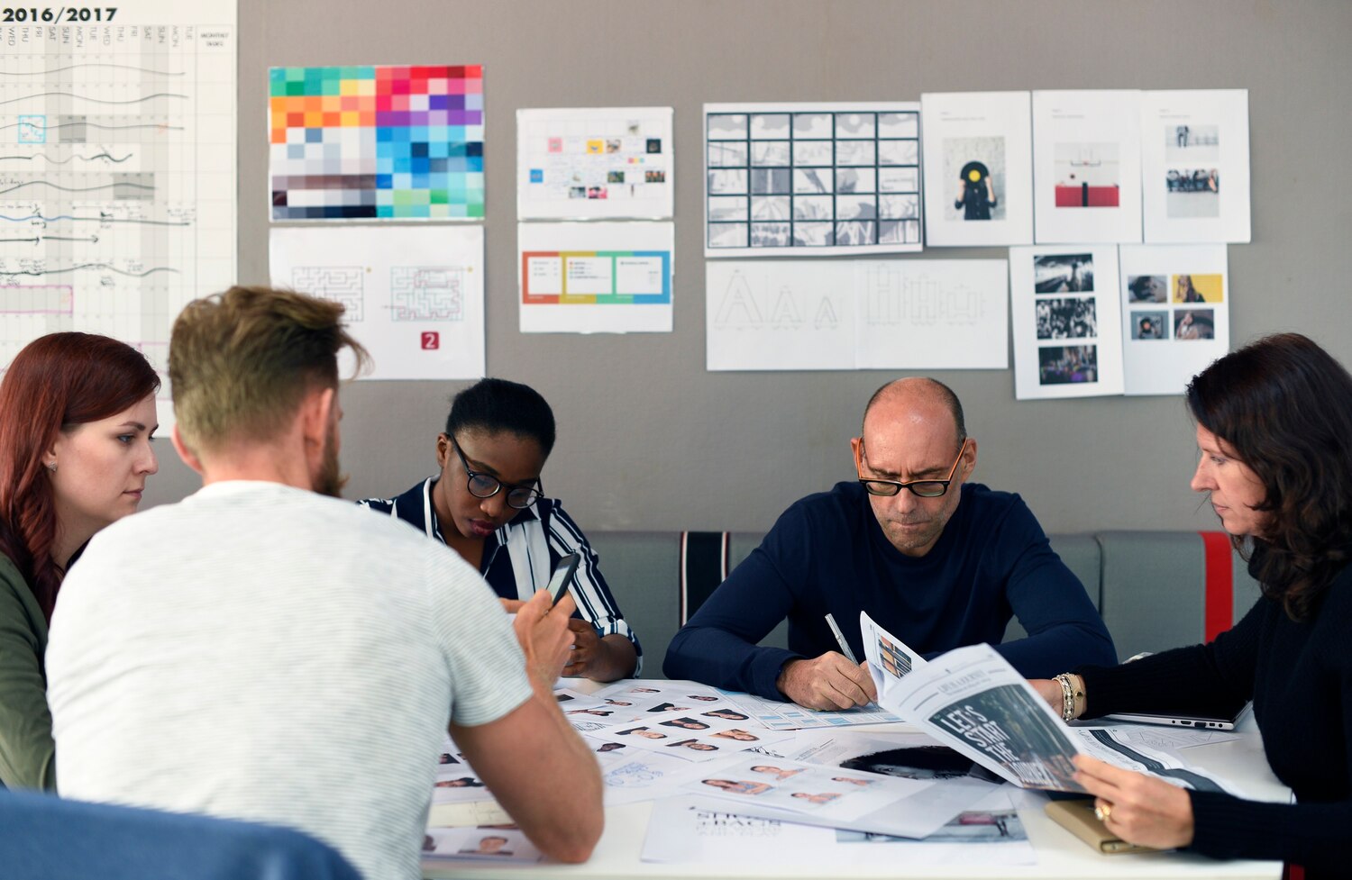 Designers and developers collaborating in Figma with a tokens repo open to plan a brand identity system rollout