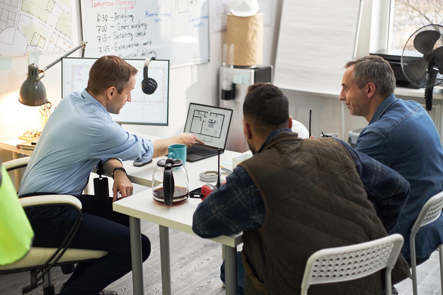 Designers and developers collaborating to map brand tokens and components for a scalable identity system