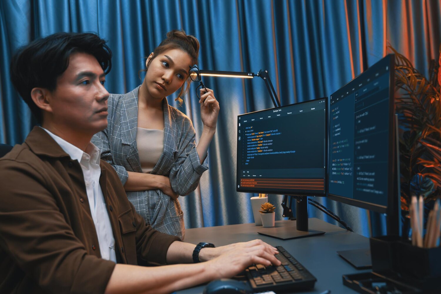 Developers pairing on automated API integration tests with a CI pipeline dashboard visible