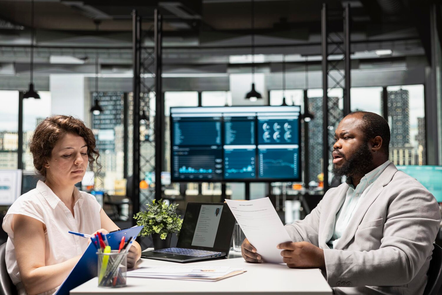 Engineers and compliance leaders evaluate AI model risk dashboards and mitigation plans during a governance review meeting