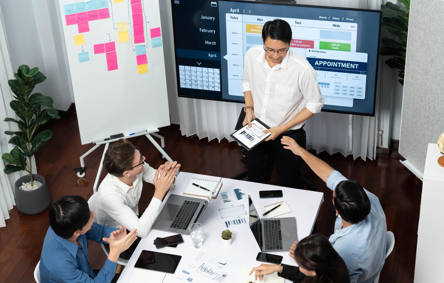 Product manager and engineers collaborating on a custom development backlog with architecture diagram visible on a shared display